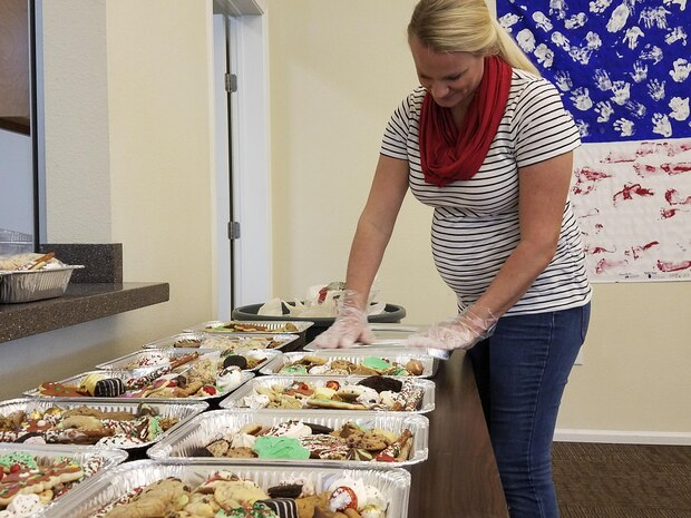 Tess Kline, Team Charleston Key Spouses member, seals individual cookie trays for the annual holiday program: Operation Cookie Drop at the Hunt Housing Office, Dec. 7, 2016. The spouses baked almost 3,000 cookies for Joint Base Charleston members.