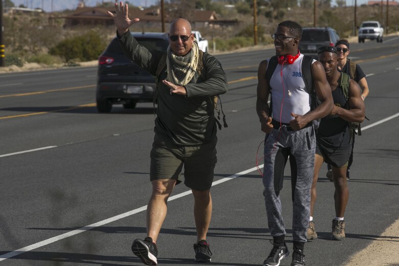 Mark Gelekto, tactical training support, 7th Marine Regiment, and Lance Cpl. Xavier Vines, tactical air operations module technician, Marine Corps Communication-Electronics School, hike together down Highway 62, Dec. 10, 2016. Gelekto organized the event to raise money to donate to children in need. (Official Marine Corps photo by Cpl. Thomas Mudd/Released)