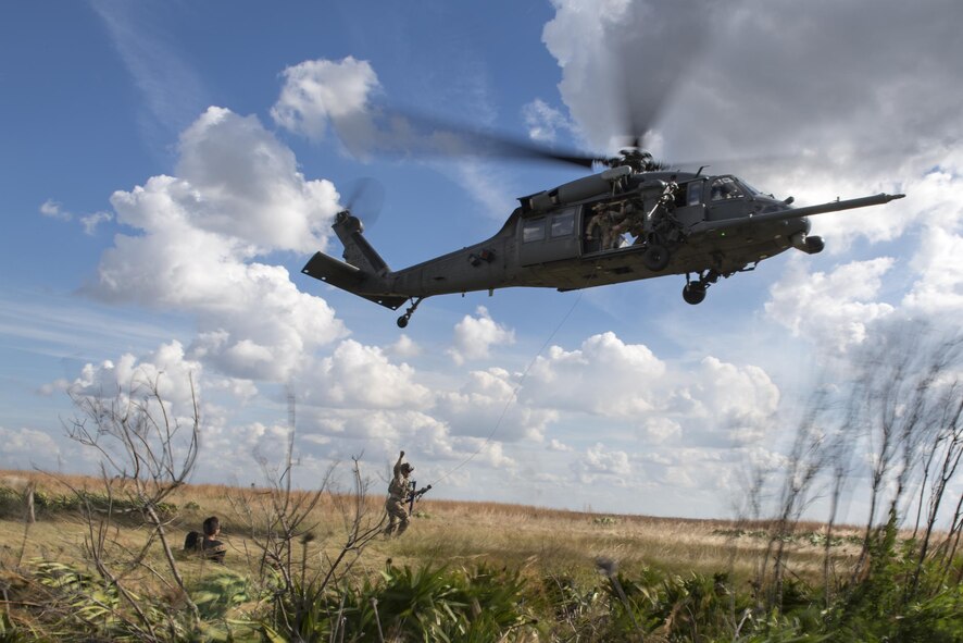 A paraescueman from the 38th Rescue Squadron communicates with aircrew from the 41st Rescue Squadron before hoisting the simulated stranded survivor into a HH-60G Pave Hawk, Dec. 12, 2016, at Avon Park Air Force Range, Fla. Airmen would randomly place themselves in the range and pretend to be a stranded survivor, providing aircrews the opportunity to practice their combat, search and rescue mission. (U.S. Air Force photo by Airman 1st Class Daniel Snider)