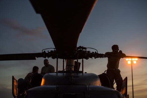 Maintainers from the 41st Helicopter Maintenance Unit perch on top of an HH-60G Pave Hawk during engine maintenance, Dec. 12, 2016, at Patrick Air Force Base, Fla. The 41st HMU worked alongside the 41st Rescue Squadron for ten days as they conducted pre-deployment “spin-up” training. The maintainers were responsible for ensuring three aircraft were combat-ready at a moment’s notice and worked around the clock to meet this requirement for both day and night missions. (U.S. Air Force photo by Staff Sgt. Ryan Callaghan)