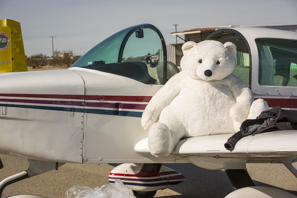 A stuffed bear sits on the wing of an aircraft that was flown by volunteers from the Redlands Airport Association to deliver toys to Twentynine Palms Airport as part of the 2nd annual Toys for Tots Fly-in, Dec. 10, 2016. (Official Marine Corps photo by Cpl. Levi Schultz/Released)
