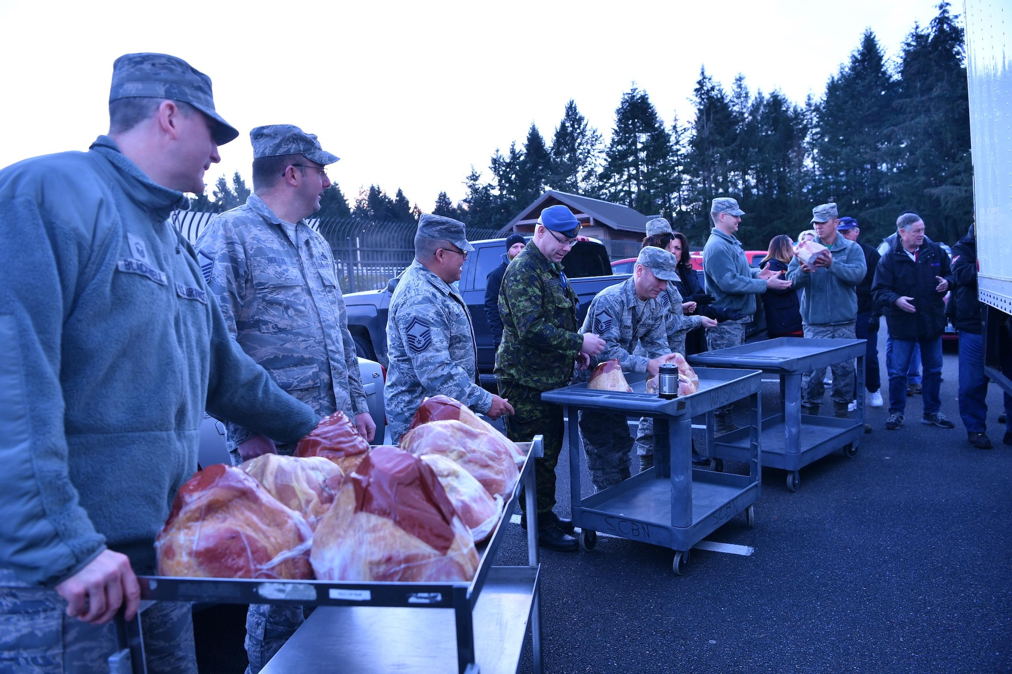 Col. Brett Bosselmann, 225th Air Defense Squadron commander, third from right, assists with the delivery of holiday hams donated to the Western Air Defense Sector during Operation Ham Grenade Dec 16.  Members of the Association of the United States Army, the Air Force Association, local business leaders and the Pierce Military and Business Alliance, delivered 20 holiday hams to WADS junior servicemembers as a way to show their appreciation and support.  (U.S. Air National Guard photo by Kimberly D. Burke)