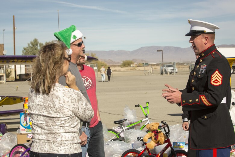 Staff Sgt. Jason Slye, company master gunner, 4th Tank Battalion, thanks volunteers from the Redlands Airport Association who delivered toys to Twentynine Palms Airport as part of the 2nd annual Toys for Tots Fly-in, Dec. 10, 2016. (Official Marine Corps photo by Cpl. Levi Schultz/Released)