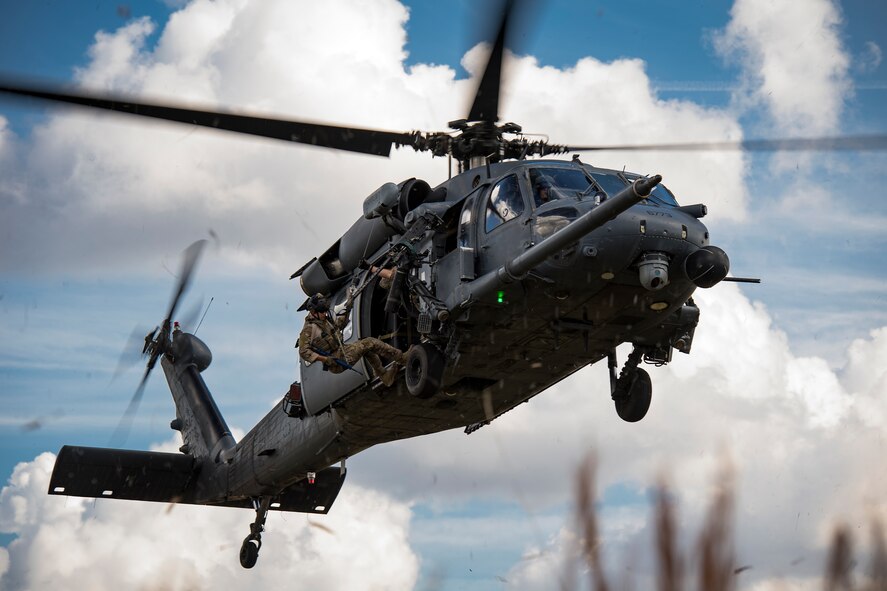 A pararescueman from the 38th Rescue Squadron prepares to exit a 41st RQS HH-60G Pave Hawk during a ‘spin-up’ exercise, Dec. 13, 2016, at Avon Park Air Force Range, Fla. During the spin-up, the 41st RQS, alongside mission partners from the 38th and 71st Rescue Squadrons, conducted high-tempo rescue operations designed to mimic the missions they will fly downrange. They based their operations out of Patrick AFB and flew missions to Avon Park Air Force Range, Fla.(U.S. Air Force photo by Staff Sgt. Ryan Callaghan)