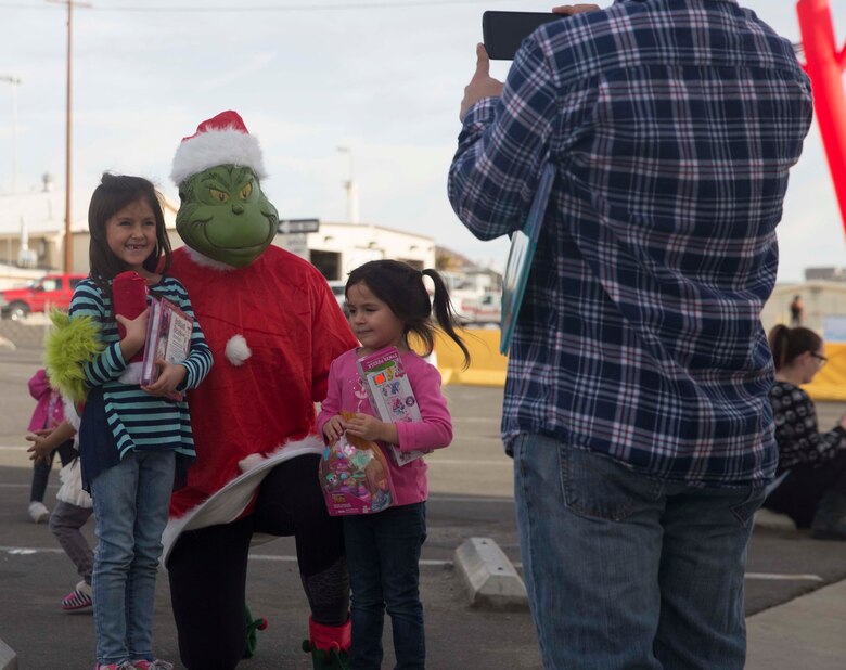 Sophia Trevino, 7, and Selene Trevino, 4, daughters of Staff Sgt. Tim Trevino, communication maintenance chief, Marine Corps Logistics Operations Group, get to meet the Grinch during Marine Corps Community Service’s annual Combat Center Toy Giveaway at the West Gym aboard Marine Corps Air Ground Combat Center, Twentynine Palms, Calif., Dec. 10, 2016. (Official Marine Corps photo by Cpl. Medina Ayala-Lo/Released)