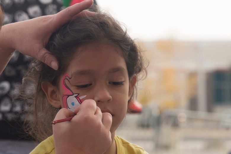 A Jolly Jumps employee paints a unicorn on Cemelia Rangel, 6, daughter of Staff Sgt. Jorge Rangel, light armored vehicle crewman, 3rd Light Armored Reconnaissance Battalion, during Marine Corps Community Service’s annual Combat Center Toy Giveaway at the West Gym aboard Marine Corps Air Ground Combat Center, Twentynine Palms, Calif., Dec. 10, 2016. (Official Marine Corps photo by Cpl. Medina Ayala-Lo/Released)