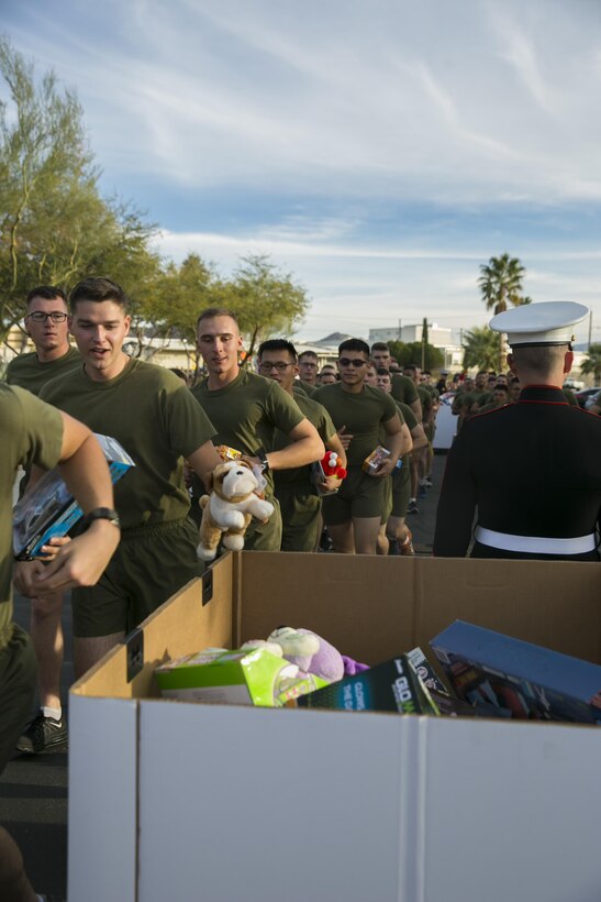 Students and staff of the Marine Corps Communication-Electronics School place toys in donation bins during the Toys for Tots Fun Run aboard Marine Corps Air Ground Combat Center, Twentynine Palms, Calif., Dec. 14, 2016. (Official Marine Corps photo by Lance Cpl. Dave Flores/Released)