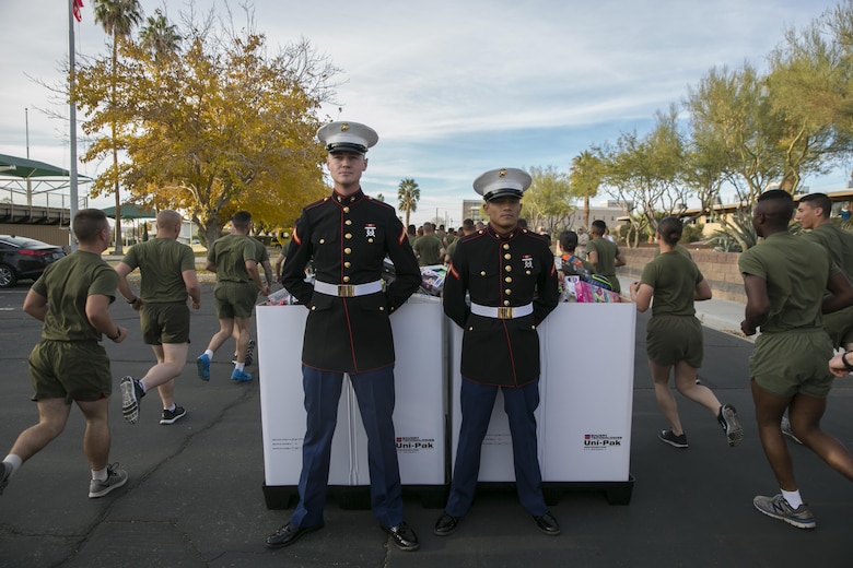 Pfc. Joshua Navarroishiki and Pfc. William Brehman, students, Marine Corps Communication-Electronics School, stand guard over toy bins during the Toys for Tots Fun Run aboard Marine Corps Air Ground Combat Center, Twentynine Palms, Calif., Dec. 14, 2016. (Official Marine Corps photo by Lance Cpl. Dave Flores/Released)