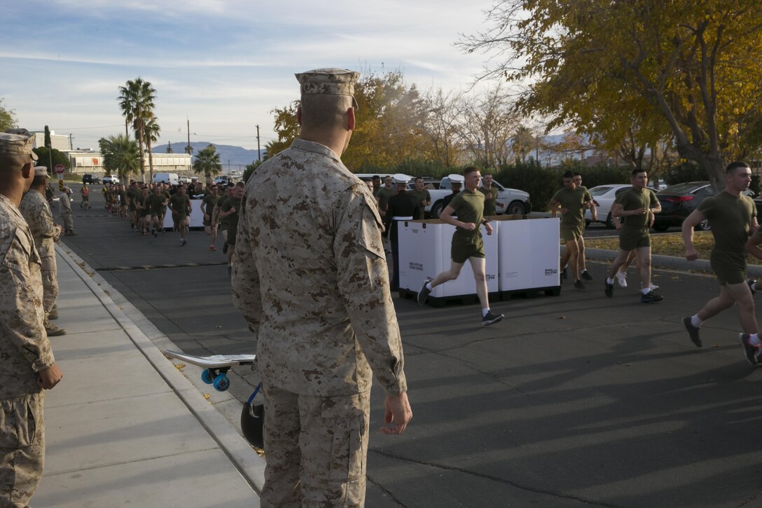 Brig. Gen. William F. Mullen III, Combat Center Commanding General, watches the students and staff of the Marine Corps Communication-Electronics School drop off donated toys during the Toys for Tots Fun Run aboard Marine Corps Air Ground Combat Center, Twentynine Palms, Calif., Dec. 14, 2016. (Official Marine Corps photo by Lance Cpl. Dave Flores/Released)
