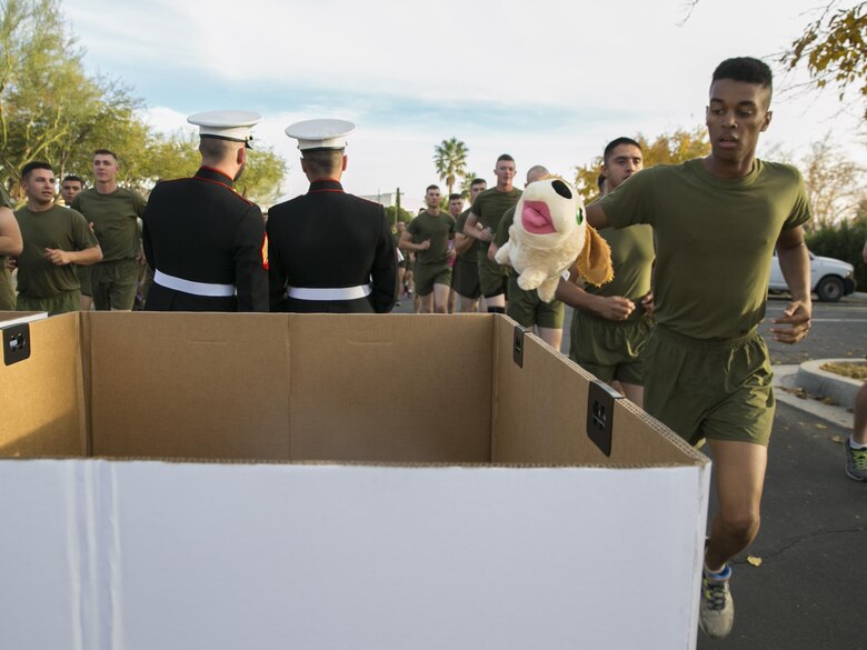 A student from the Marine Corps Communication-Electronics School drops off a toy in a donation bin during the Toys for Tots Fun Run aboard Marine Corps Air Ground Combat Center, Twentynine Palms, Calif., Dec. 14, 2016. (Official Marine Corps photo by Lance Cpl. Dave Flores/Released)