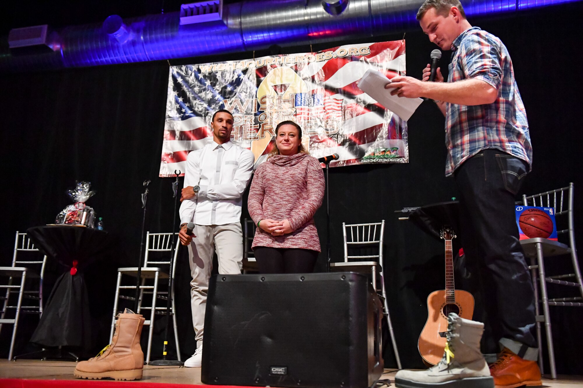 Staff Sgt. Nicole Drapeau, 388th Maintenance Squadron, stands beside George Hill while Jeff Wells reads details of her granted holiday wish during the G3 Holiday Bash, Park City, Utah, Dec. 15, 2016. Four local military families were surprised with granted wishes during the event. (U.S. Air Force photo/R. Nial Bradshaw)