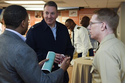 U.S. Air Force Col. Robert Lyman, Joint Base Charleston commander, center, U.S. Navy Capt. Robert Hudson, 628th Air Base Wing deputy commander, right and Alfonso Rodgers, RiverDogs group sales representative, talk during the Federal Executive Association of the Greater Charleston Area Holiday Coffee Drop-in at Coast Guard Sector Charleston’s Brass Buckle conference room Dec. 16, 2016. The Federal Executive Association promotes coordination of federal agency programs for maximum public benefit and to foster stronger relationships between the agencies’ management officials.