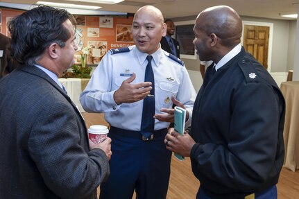 U.S. Air Force Col. Jimmy Canlas, 437th Airlift Wing commander, middle, talks to Ched Beam, 628th Air Base Wing executive director and Lt. Col. Dennis Major, 841st Transportation Battalion commander, during the Federal Executive Association of the Greater Charleston Area Holiday Coffee Drop-in at Coast Guard Sector Charleston’s Brass Buckle conference room Dec. 16, 2016. The Federal Executive Association promotes coordination of federal agency programs for maximum public benefit and to foster stronger relationships between the agencies’ management officials. Canlas is the military co-chair of the FEA in addition to his role as wing commander.