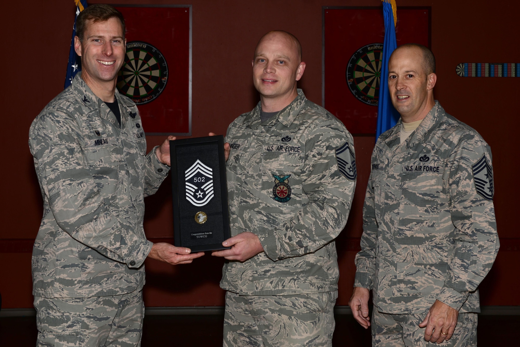 U.S. Air Force Col. David Mineau, the 354th Fighter Wing commander, and Chief Master Sgt. Brent Sheehan, the 354th FW command chief, present Senior Master Sgt. Joey Meininger, the 354th Civil Engineer Squadron deputy fire chief, with his newest stripe and line number for his selection to the highest enlisted rank of chief master sergeant Dec. 9, 2016, at Eielson Air Force Base, Alaska. Meininger was informed on Dec. 7 that he made it to the top one percent of the enlisted force. This photo was edited for propriety. (U.S. Air Force photo by Airman Eric M. Fisher)