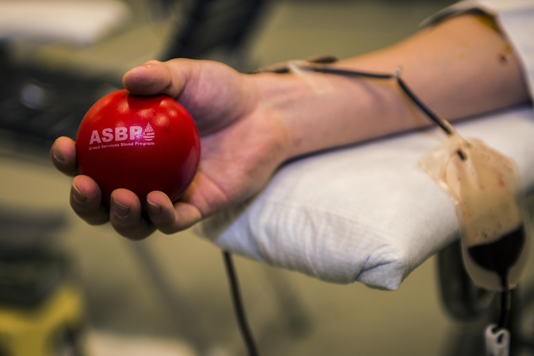 Airman 1st Class Shawn Green, 27th Special Operations Civil Engineer Squadron power production technician, periodically squeezes a ball to increase blood flow to his arm during an Armed Forces Blood Program blood drive in bldg. 54’s gym on Nov. 16, 2016, Cannon AFB, N.M. An ASBP blood drive accumulates nearly 50 units of blood on average during site visits. (U.S. Air Force photo by Senior Airman Luke Kitterman/Released)