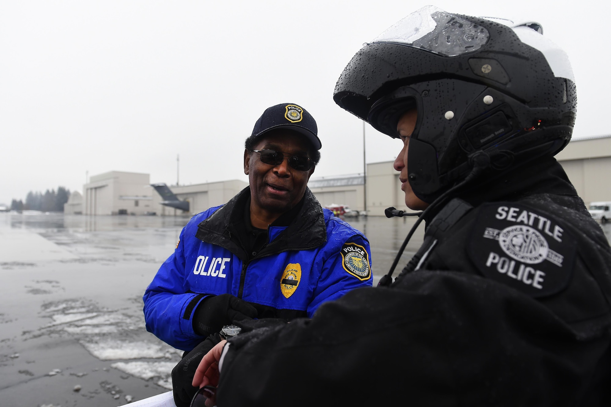 Charles Thornton, Joint Base Lewis-McChord Directorate of Emergency Services joint operations officer for McChord Filed, coordinates with a Seattle Police Officer Dec. 9, 2016, on McChord Field, Wash. Thornton was the lead coordinator and point of contact for the more than 450 vehicles and 1,250 people who staged at JBLM for the funeral of Tacoma Police Officer Reginald “Jake” Gutierrez.  (U.S. Air Force photo/Tech. Sgt. Tim Chacon)

