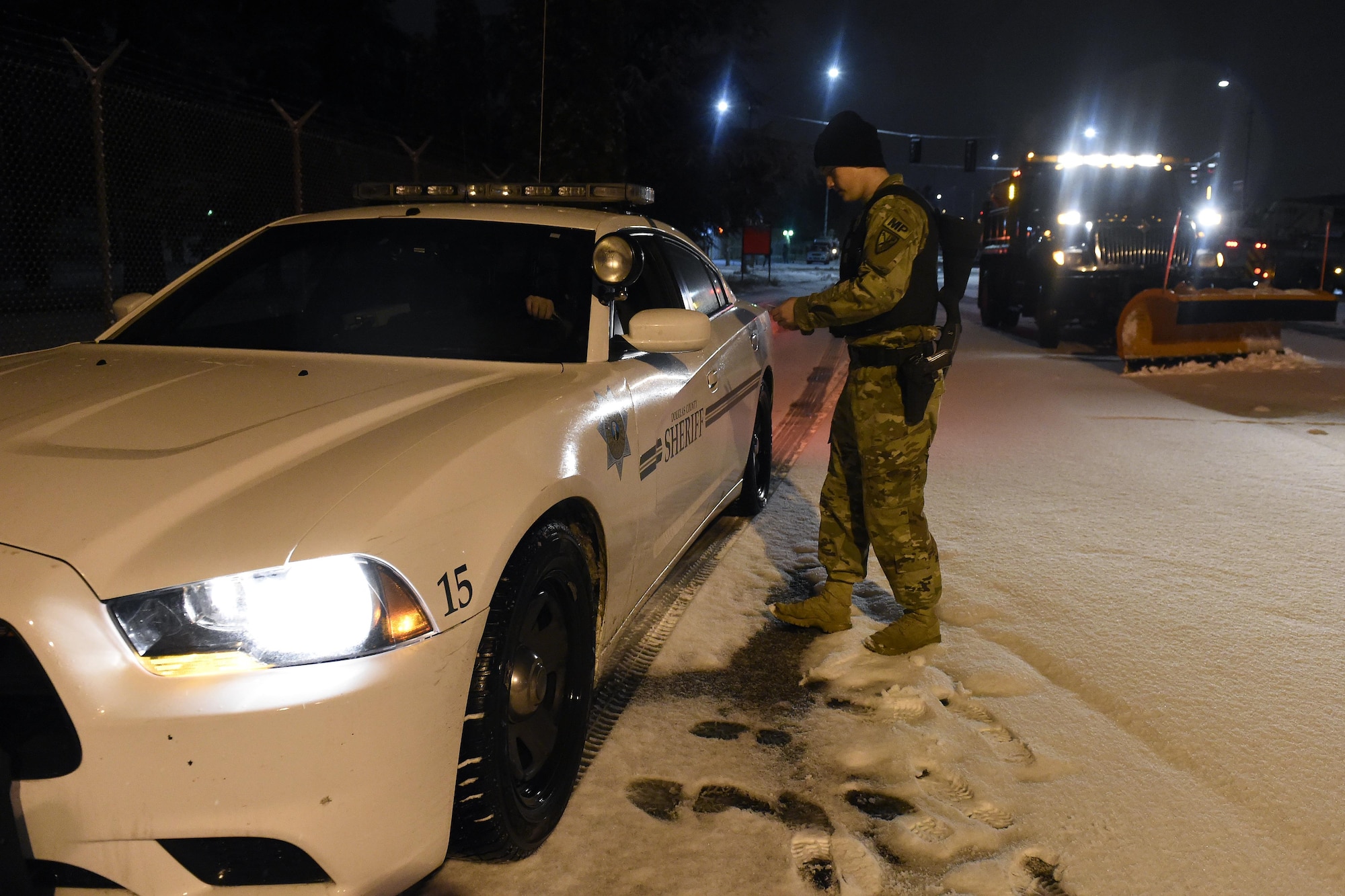 A Solider from the 42nd Military Police Brigade stationed at Joint Base Lewis-McChord checks the IDs of a Douglas County Sheriff arriving at McChord Field, Wash. Dec. 9, 2016. The Sheriff came to JBLM to participate in the funeral procession for Tacoma Police Officer Reginald “Jake” Gutierrez. (U.S. Air Force photo/Tech. Sgt. Tim Chacon) 