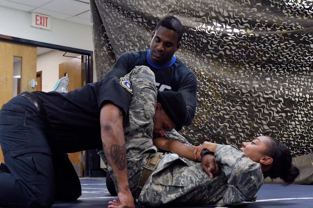 Senior Airman Jexsira Watts, 633rd Security Forces Squadron response force leader, applies a triangle choke on Tony Molette, 633rd SFS law enforcement officer, with assistance from Lorenz Larkin, a professional Ultimate Fighting Championship mixed martial artist, during a combatives course at Joint Base Langley-Eustis, Va., Dec. 8, 2016. Larkin’s appearance was part of a distinguished visitor tour where military members and dependents had an opportunity to meet and get autographs from Shevchenko, other UFC fighters and radio hosts throughout the week. During the tour the UFC athletes spoke with service members about similarities between the UFC and the U.S. Armed Forces. (U.S. Air Force photo by Staff Sgt. Nick Wilson)