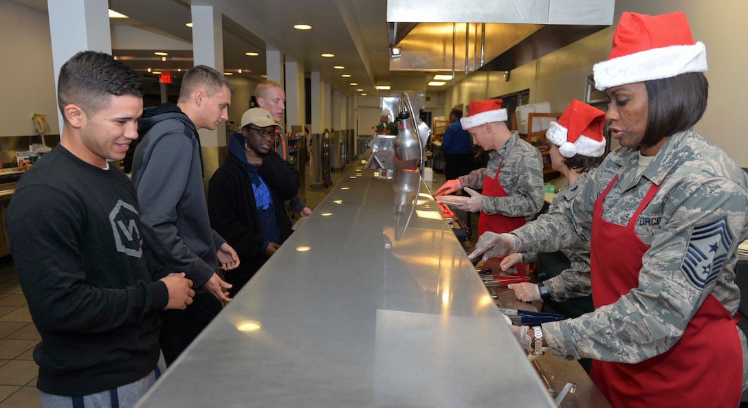 Leadership from the National Air and Space Intelligence center serve dinner at the Pitsenbarger Dining Facility here Dec 13. Each year the dining facility staff prepares a special holiday themed dinner for patrons. Throughout the evening leaders from across Wright-Patterson served the dinner to Airmen as a gesture of appreciation for their hard work. (U.S. Air Force photo/Senior Airmen Samuel Earick) 