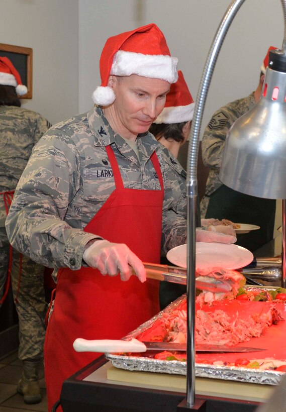 Col. Sean Larkin National Air and Space Intelligence center commander, serves dinner at the Pitsenbarger Dining Facility here Dec 13. Each year the dining facility staff prepares a special holiday themed dinner for patrons. Throughout the evening leaders from across Wright-Patterson served the dinner to Airmen as a gesture of appreciation for their hard work. (U.S. Air Force photo/Senior Airmen Samuel Earick) 