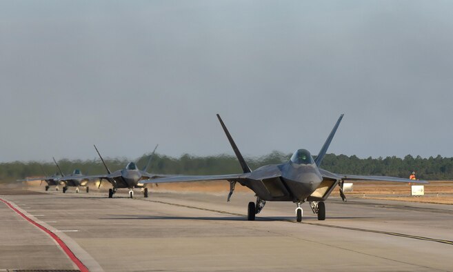 F-22 Raptors taxi down the flightline on Tyndall Air Force Base, Fla., during Checkered Flag 17-1, Dec. 8, 2016. During the exercise, Tyndall’s F-22s were joined by F-35A Lightning IIs, F-15E Strike Eagles, F-16 Fighting Falcons, HH-60G Pave Hawks and an E-3 Sentry (AWACS) to ensure seamless integration in a simulated deployed location. (U.S. Air Force photo/Staff Sgt. Alex Fox Echols III)