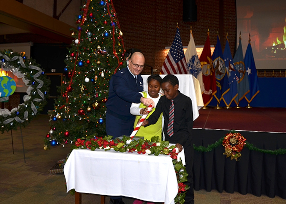 Two Bensley Elementary School fifth graders, Angela Marinex, center, and Andersson Castro, left, along with Defense Logistics Agency Aviation Commander Air Force Brig. Gen. Allan Day throw the switch to light the tree during the annual Tree Lighting Ceremony Dec. 14, 2016 in the Frank B. Lotts Conference Center on Defense Supply Center Richmond, Virginia.