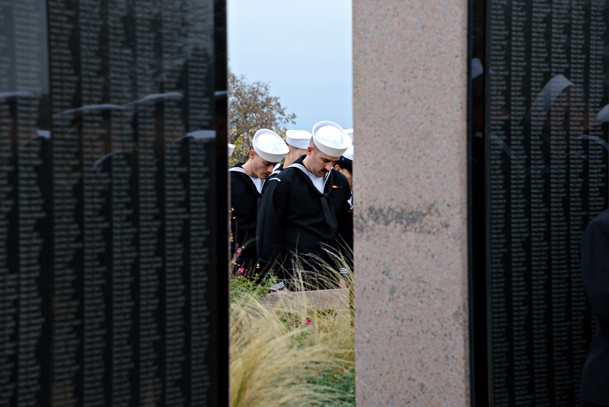 Sailors from Strategic Communications Wing ONE pay respect at the Veteran’s Memorial near the Oklahoma State Capitol, to the more than 2,400 Sailors and Marines who were killed at the attacks on Pearl Harbor 75 years ago. Out of the more than 2,400 lives lost, 429 were on the USS Oklahoma. (Air Force photo by Kelly White)