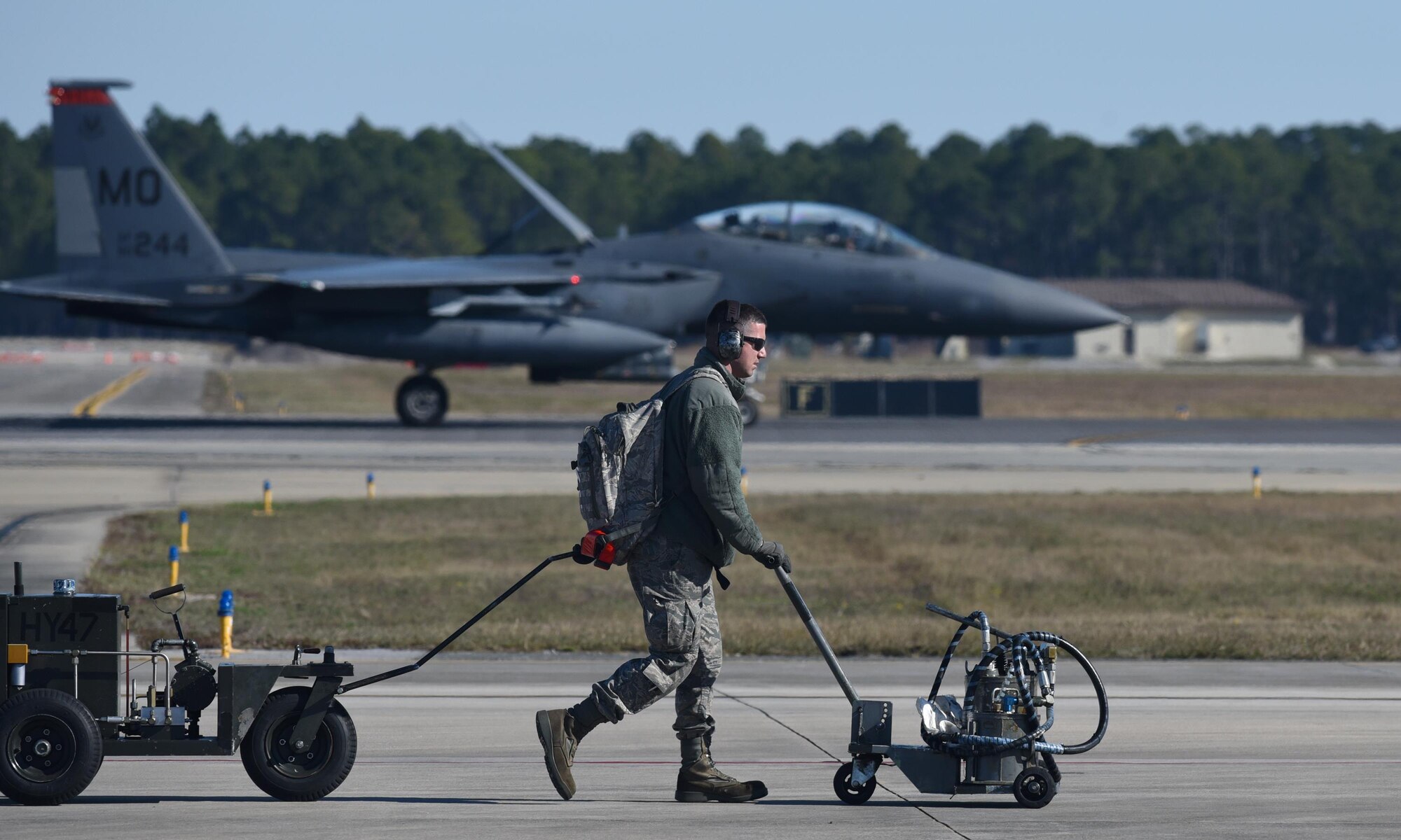 U.S. Air Force Tech. Sgt. Sean Weygandt, 391st Aircraft Maintenance Unit crew chief, pulls hydraulic and oil servicing carts across the flightline at Tyndall Air Force Base, Fla., Dec. 16, 2016. During exercise Checkered Flag 17-1, maintenance personnel from several units and different airframes integrated their skills and efforts to make the mission happen. (U.S. Air Force photo by Staff Sgt. Alex Fox Echols III/Released)