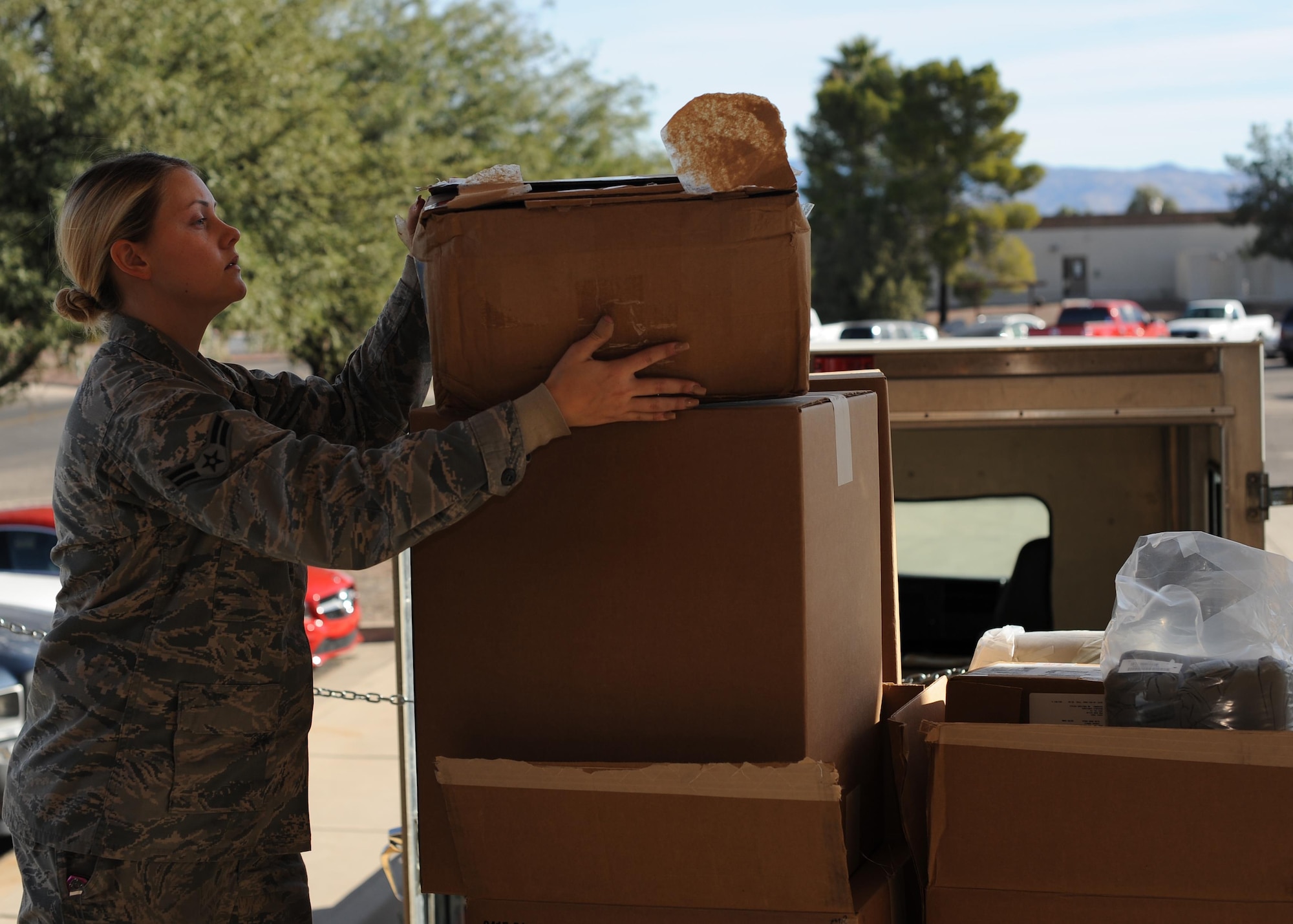 U.S. Air Force Airman 1st Class Katherine Street, 355th Logistics Readiness Squadron vehicle operator, receives packages for delivery at Davis-Monthan Air Force Base, Ariz., Dec. 14, 2016. Once supplies are delivered to the installation, LRS distributes them to individual units across the base allowing supplies to be readily available. (U.S. Air Force photo by Senior Airman Ashley N. Steffen)