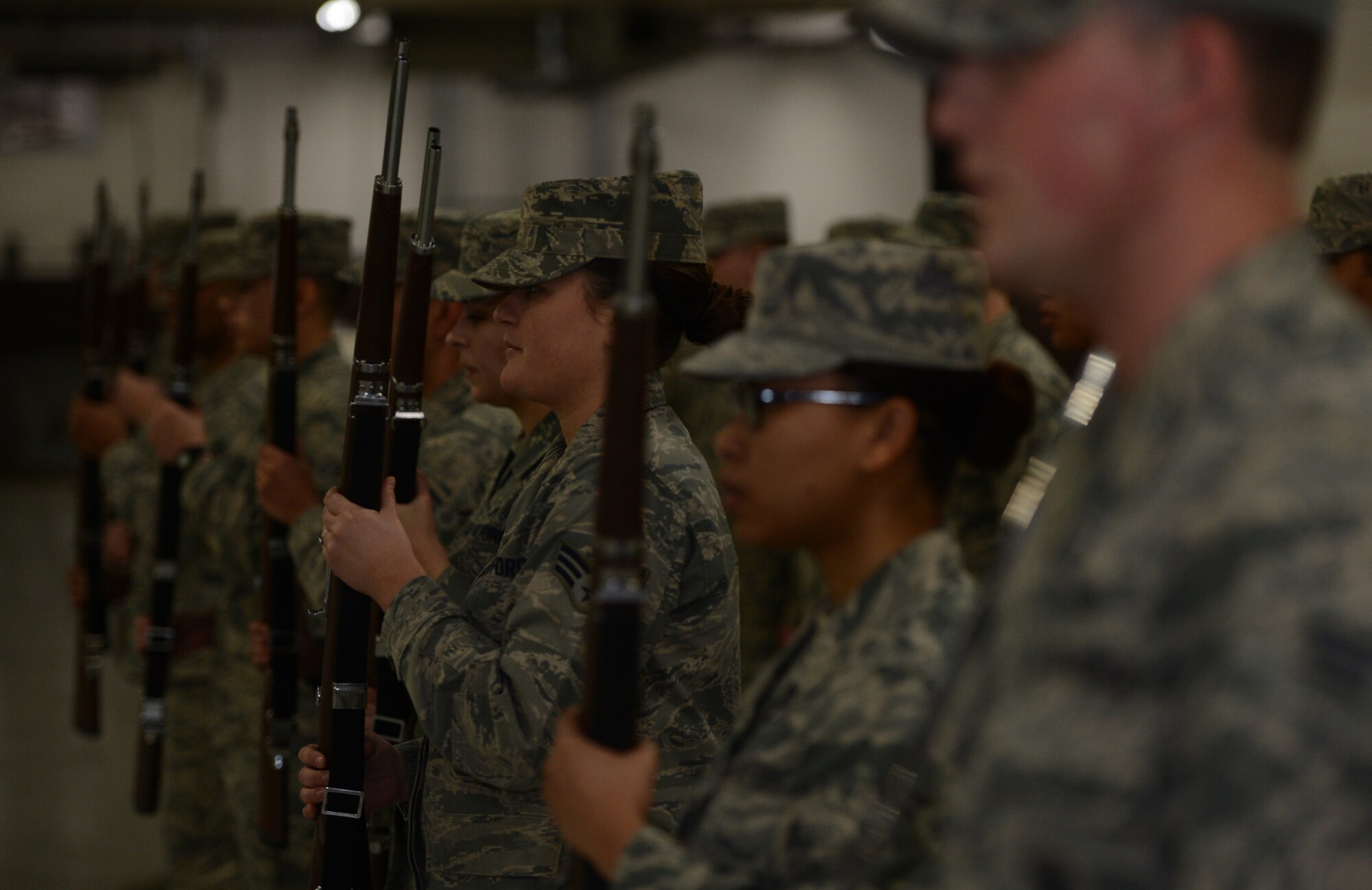 Airmen from the McChord Field Honor Guard hold rifles while standing at attention during a change of responsibility ceremony Dec. 13, 2016 at Joint Base Lewis-McChord, Wash. The transfer of rifles during the ceremony symbolized the transfer of responsibility among the incoming and outgoing honor guard flight. (U.S. Air Force photo/Senior Airman Jacob Jimenez) 