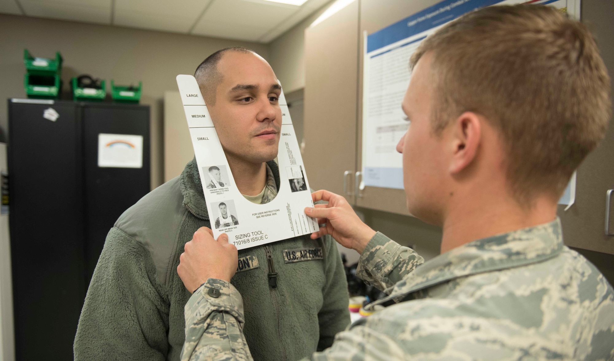 Senior Airman Ants Vahk (right), 92nd Aerospace Medicine Squadron bioenvironmental engineer, sizes Staff Sgt. William Anderson (left), 92nd Maintenance Squadron munitions systems technician, with a sizing tool Dec. 7, 2016 at Fairchild Air Force Base, Washington. The sizing tool gives an estimation on what size mask a person should wear. (U.S. Air Force photo/Senior Airman Nick J. Daniello)