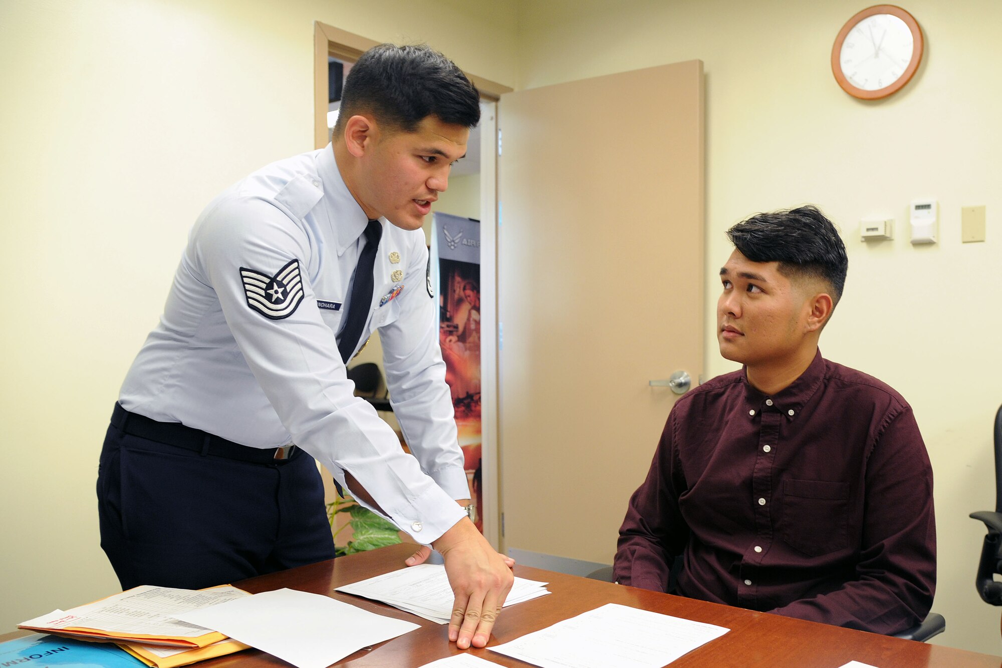 U.S. Air Force Tech. Sgt. Michael Shinohara, an Air Force Reserve recruiter based out of Joint Base Pearl Harbor-Hickam, Hawaii, explains the enlistment contract to Bryson Primacio, of Kapolei, who is joining the 48th Aerial Port Squadron as an Air Transportation specialist, at JBPH-H, Nov. 30, 2016. The 48th APS supports the 624th Regional Support Group's mission to deliver mission essential capability through combat readiness, quality management and peacetime deployments in the Pacific area of responsibility. (U.S. Air Force photo by Master Sgt. Theanne Herrmann) 
