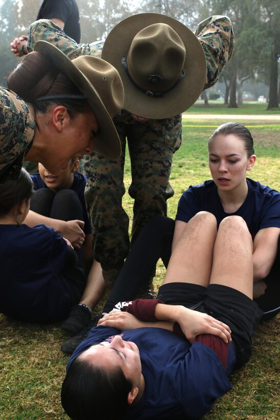 Drill Instructors Staff Sgt. MaryAnn Huffine, left, and Sgt. Jasmine James encourage future Marines to conduct crunches within the two minutes their allotted in order to pass the crunch portion of the Initial Strength Test during a female future Marine function for Recruiting Station Los Angeles at Sherman Oaks Recreation Park, Dec. 10, 2016. (U.S. Marine Corps photo by Staff Sgt. Alicia R. Leaders/Released)
