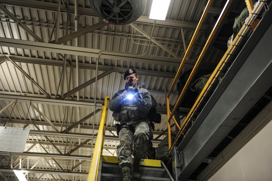 U.S. Air Force Airman 1st Class Trevor Holman, a 354th Security Forces Squadron response force leader, scans the area as he walks down the stairs Dec. 14, 2016, at the 168th Logistics Readiness Squadron building on Eielson Air Force Base, Alaska. Holman was participated in an active shooter drill hosted by the 168th Wing and 354th Fighter Wing during Arctic Gold 17-2. (U.S. Air Force photo by Airman Isaac Johnson)