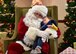 A child rests with Santa after waiting in line at the Niagara Falls Air Reserve Station on December 17, 2016. Santa made his annual visit aboard a Niagara C-130 Hercules for the last time as the 914th Airlift Wing is transitioning to the KC-135 Stratotanker. (U.S. Air Force photo by Staff Sgt. Richard Mekkri) 