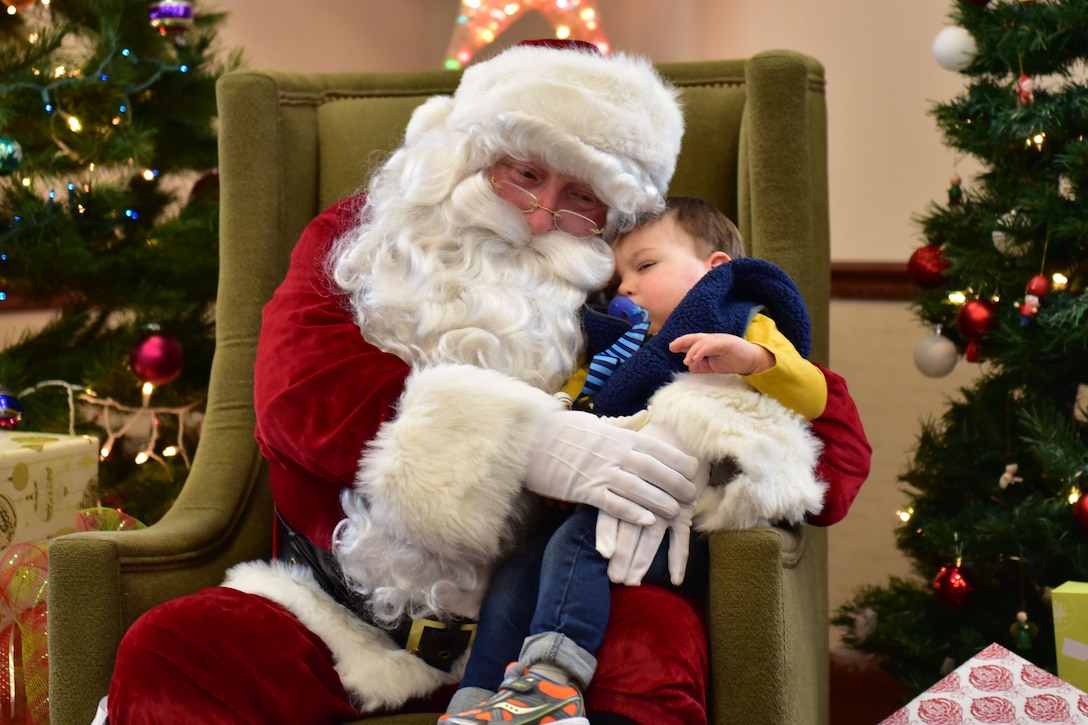 A child gets a hug from Santa after waiting in line at the Niagara Falls Air Reserve Station, Dec. 17, 2016. Air Force photo by Staff Sgt. Richard Mekkri