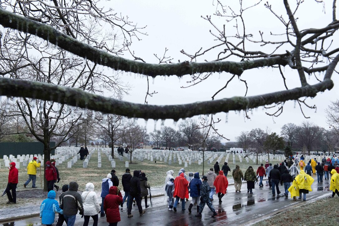 Service members, veterans and other volunteers walk into Arlington National Cemetery, Va., to participate in Wreaths Across America, Dec. 17, 2016. This is the 25th year that people have placed wreaths at Arlington for the event. Army photo by Rachel Larue