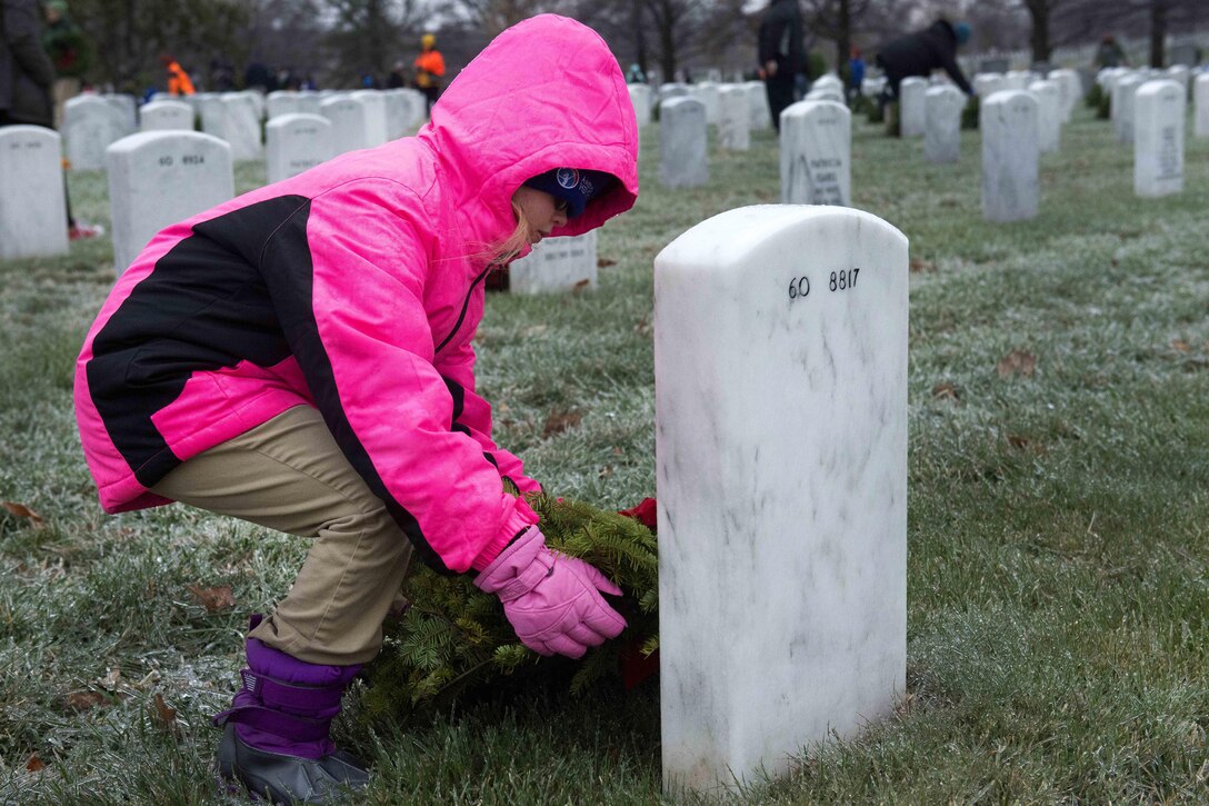 Sarah Kilareski, 10, places a wreath at a headstone during Wreaths Across America at Arlington National Cemetery, Va., Dec. 17, 2016. Army photo by Rachel Larue