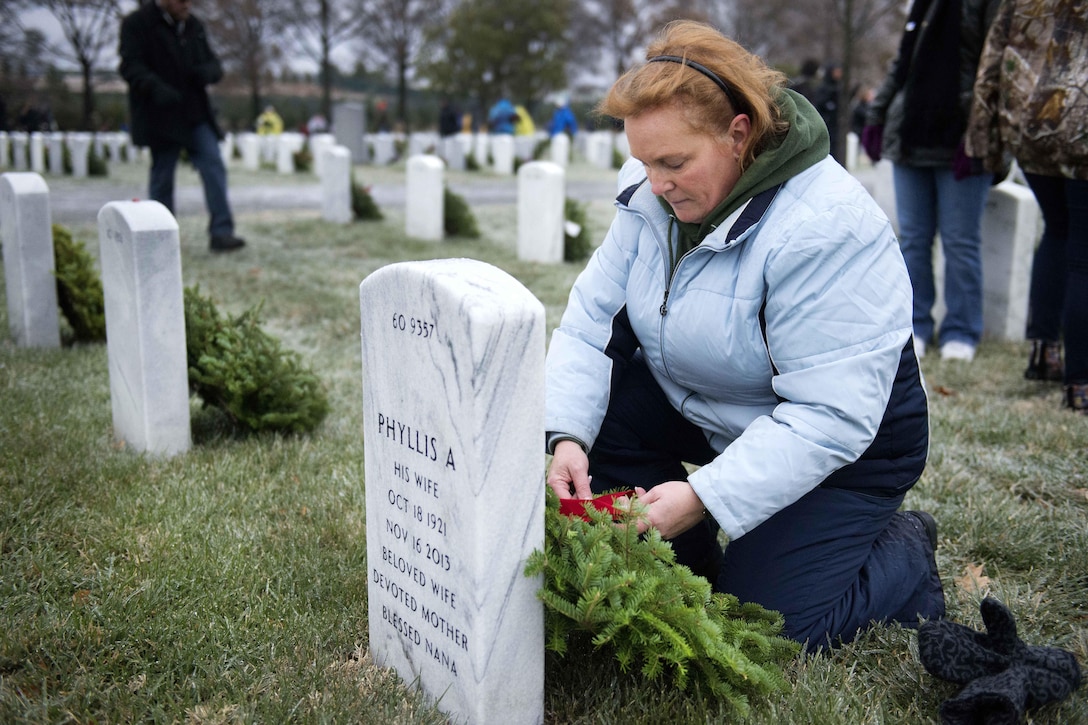 Joanne Trut places a wreath on a headstone in Section 60 during Wreaths Across America at Arlington National Cemetery, Va., Dec. 17, 2016. Trut, from Toms River, N.J., said that while her son made it home, she participated in the event to honor those that did not. Army photo by Rachel Larue