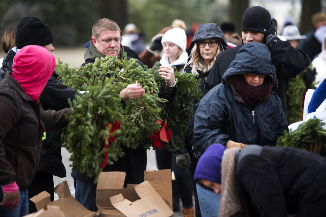 Volunteers pick up wreaths at a truck to place them at headstones during Wreaths Across America at Arlington National Cemetery, Va., Dec. 17, 2016. Army photo by Rachel Larue