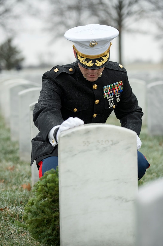 Marine Corps Maj. Carl Tucker touches the grave of Navy veteran and former Defense Department employee Robert Henry Bruette after placing a wreath at his headstone during Wreaths Across America at Arlington National Cemetery, Va., Dec. 17, 2016. Tucker, who has family and friends buried in Arlington, is an education officer at the Marine Corps University in Quantico, Va. DoD photo by EJ Hersom