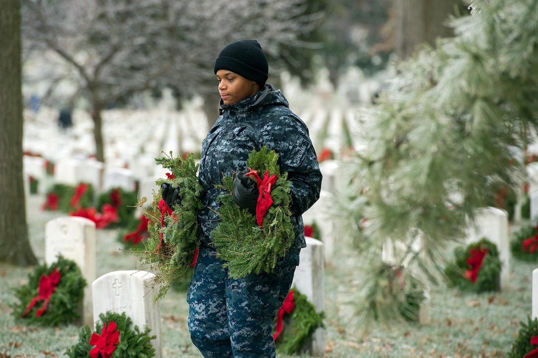Navy Petty Officer 3rd Class Shardell Thomas carries wreaths to be placed at headstones during Wreaths Across America in Arlington National Cemetery, Va., Dec. 17, 2016. DoD photo by EJ Hersom