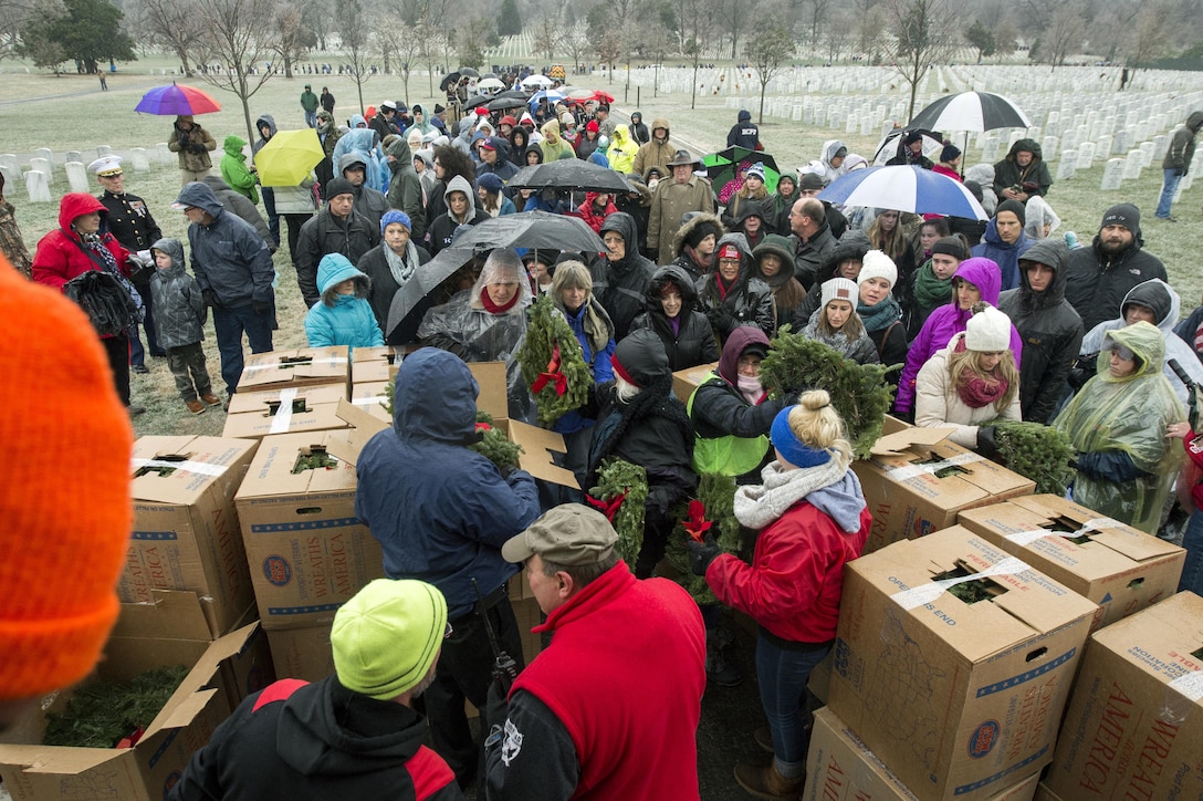 Service members, veterans, family members and other volunteers wait in freezing rain to receive wreaths to place at headstones at Arlington National Cemetery, Va., Dec. 17, 2016, during Wreaths Across America. DoD photo by EJ Hersom