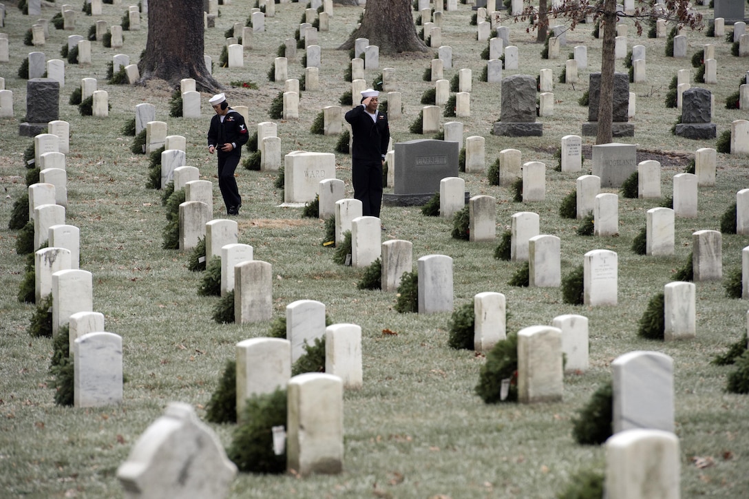 Navy Petty Officer 3rd Class Sammy Quinene salutes after placing a wreath at a headstone during Wreaths Across America at Arlington National Cemetery, Va., Dec. 17, 2016. Quinene is an aviation support equipment technician assigned to the USS Abraham Lincoln. DoD photo by EJ Hersom