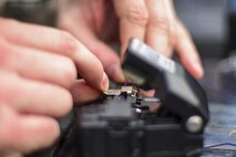 U.S. Air Force Staff Sgt. Adam Nichols, 51st Communications Squadron cable and antenna technician, cuts a wire down to size during a joint communications exercise at Gwanju Air Base, Republic of Korea, Dec. 13, 2016. Nichols and several other 51st CS Airmen worked alongside their ROK air force counterparts to restore network and telephone functionality in a simulated wartime environment during the exercise. (U.S. Air Force photo by Senior Airman Victor J. Caputo)