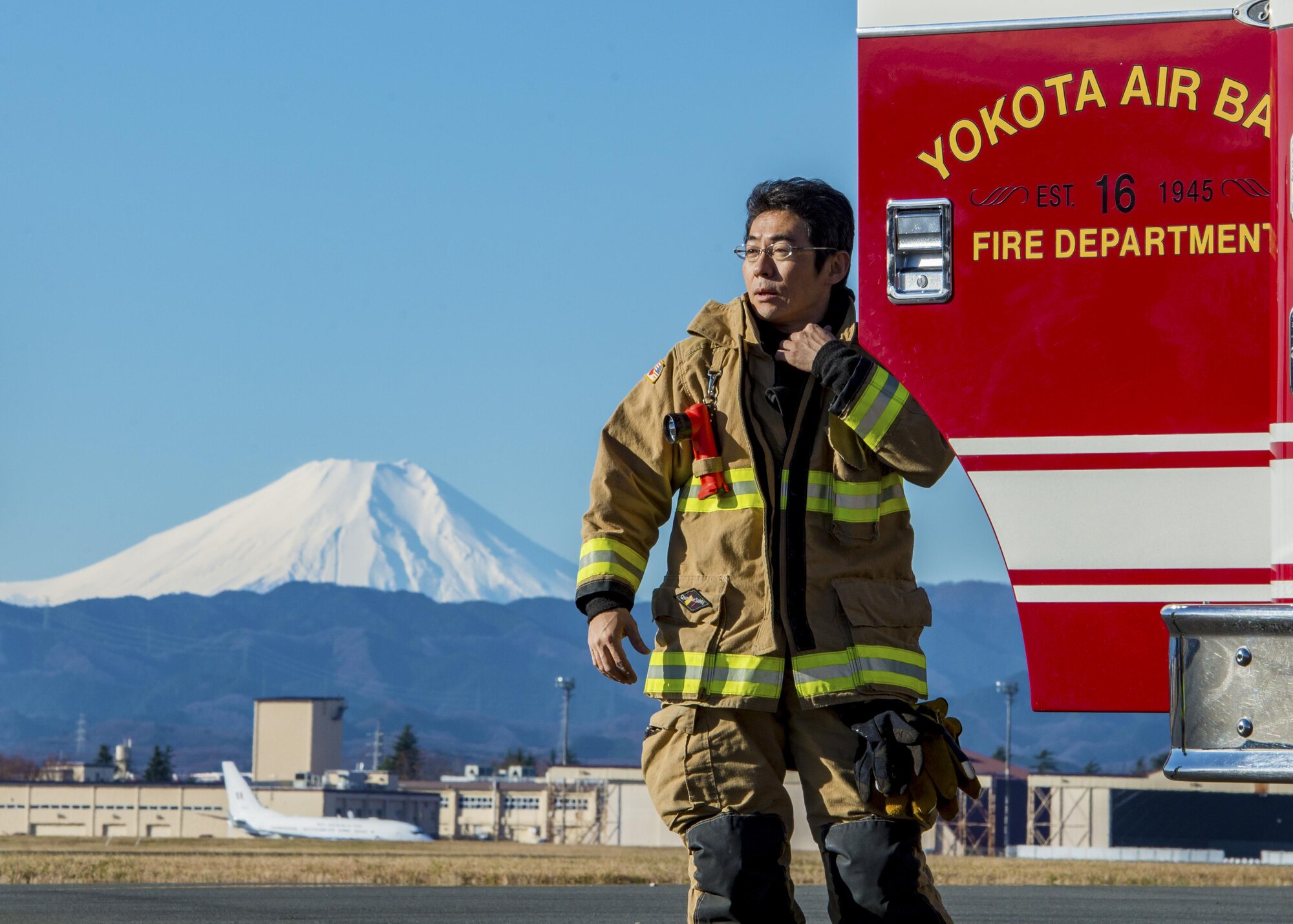 A firefighter with the 374th Civil Engineer Squadron prepares for a live fire training exercise on Dec. 15, 2016, at Yokota Air Base, Japan. The live fire training consisted of a simulated aircraft in need of assistance on a runway with two engine fires and leaking fuel spreading on the ground. (U.S. Air Force photo by Airman 1st Class Donald Hudson)
