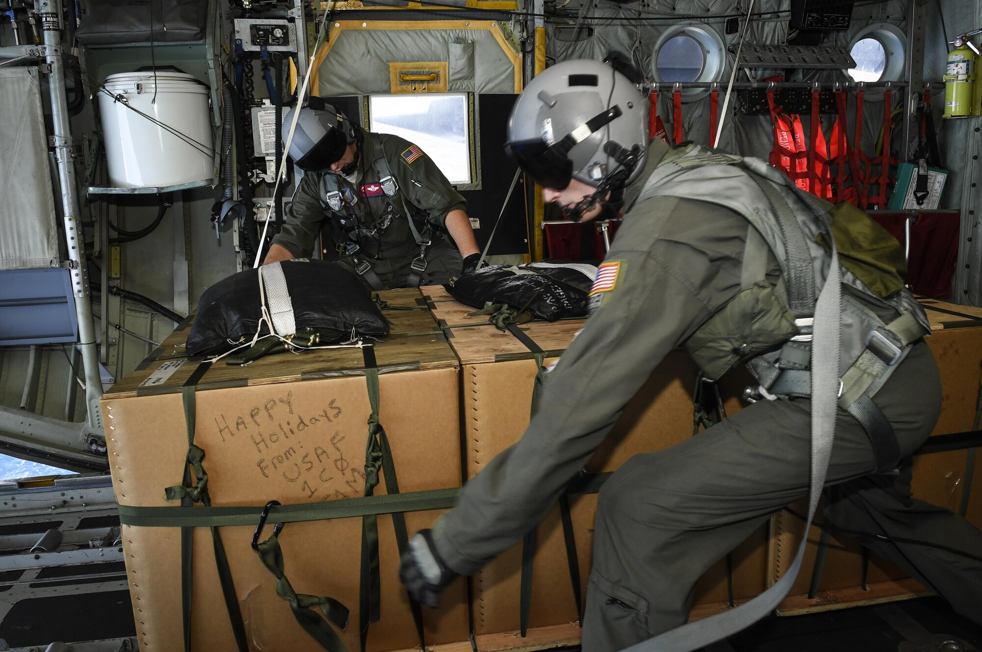 Tech. Sgt. Jonathan Lange, left, 36th Airlift Squadron C-130H Hercules instructor loadmaster, and Senior Airman Nicholas Oswald, 36 AS C-130H Hercules loadmaster, prepare to push bundles of donated goods over the Pacific islands during Operation Christmas Drop, Dec. 11, 2016. Every December, C-130H Hercules aircrews from Yokota head to Andersen Air Force Base to execute low-cost, low-altitude humanitarian airdrops to islanders throughout the Commonwealth of the Northern Marianas, Federated States of Micronesia and Republic of Palau. (U.S. Air Force photo by Senior Airman Elizabeth Baker)