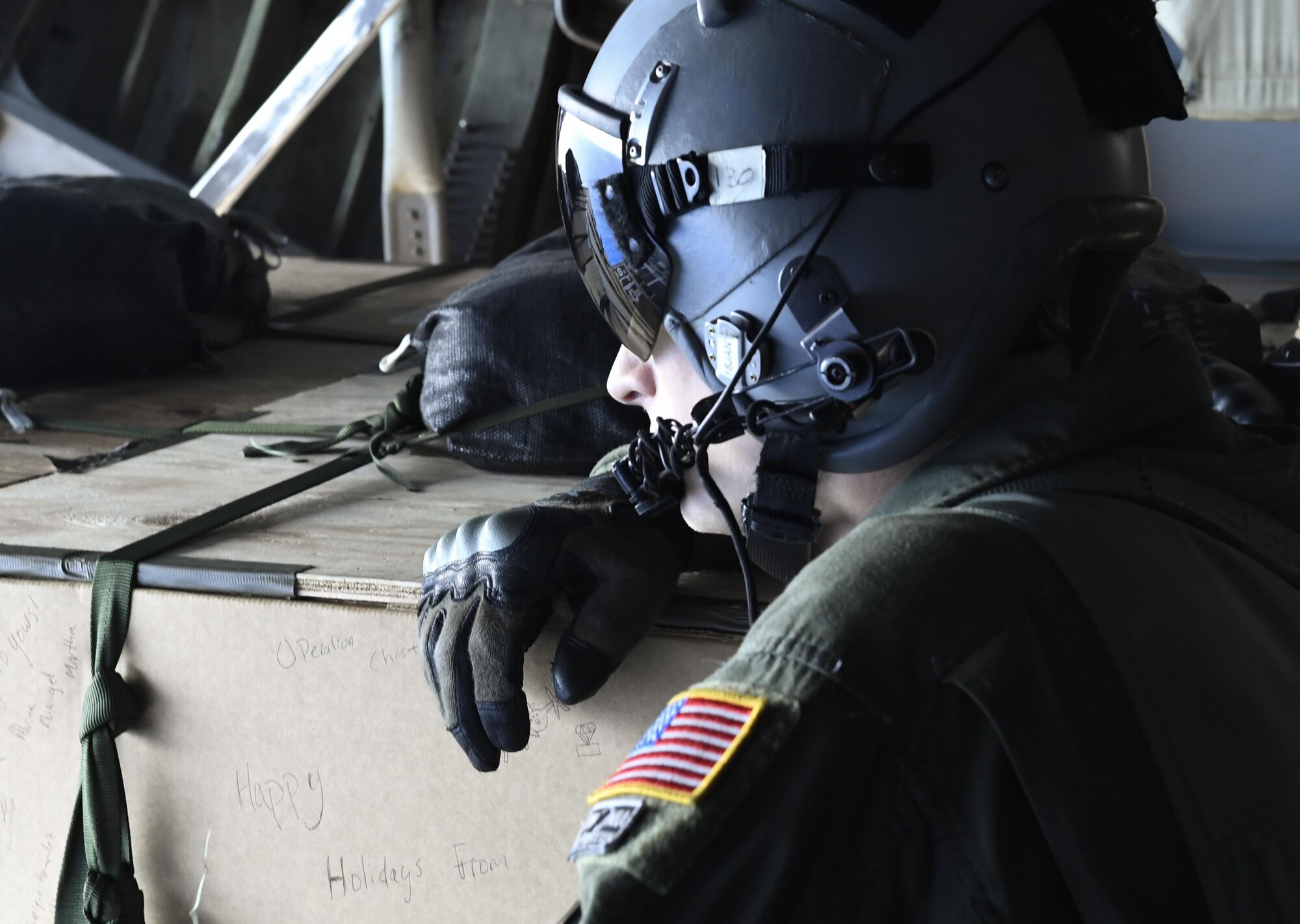 Senior Airman Nicholas Oswald, 36th Airlift Squadron C-130H Hercules loadmaster, waits to push bundles of donated goods over the Pacific islands during Operation Christmas Drop, Dec. 11, 2016. The C-130 performed a bundle drops over the Micronesian Islands. Each year OCD provides aid to over 30,000 islanders in Chuuk, Palau, Yap, Marshall Islands and Commonwealth of the Northern Mariana Islands. (U.S. Air Force photo by Senior Airman Elizabeth Baker)