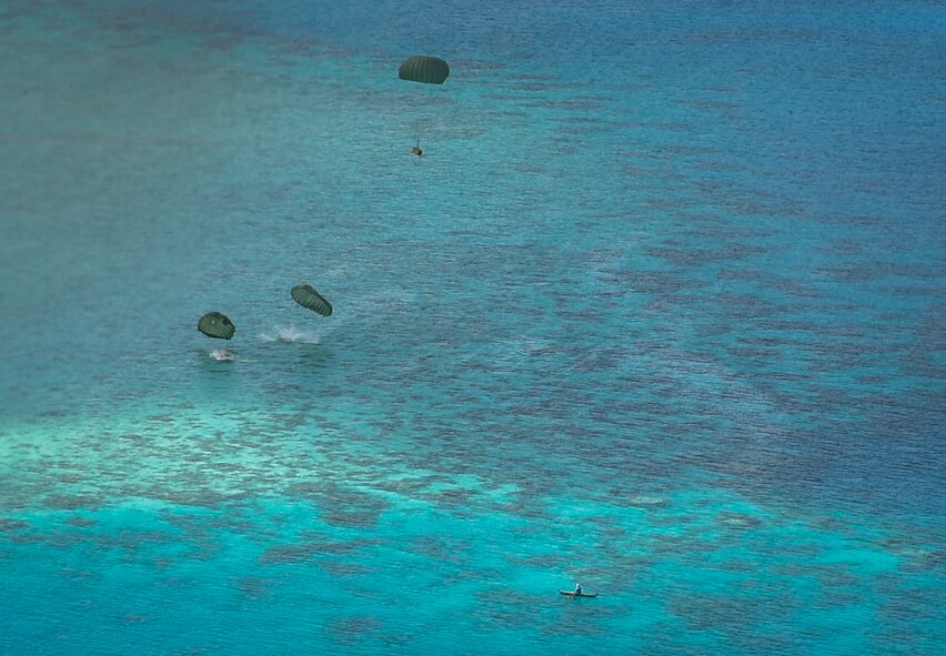Bundles of donated goods reach their drop zone in the Pacific islands during Operation Christmas Drop, Dec. 11, 2016. Every December, C-130H Hercules aircrews from Yokota head to Andersen Air Force Base to execute low-cost, low-altitude humanitarian airdrops to islanders throughout the Commonwealth of the Northern Marianas, Federated States of Micronesia and Republic of Palau. (U.S. Air Force photo by Senior Airman Elizabeth Baker)