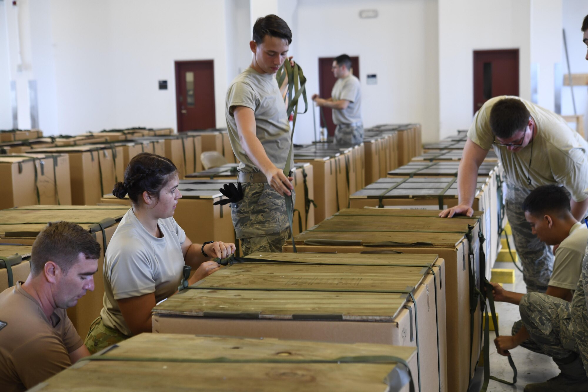 Airmen with the 374th Airlift Wing Combat Mobility Flight and the Royal Australian Air Force rig bundles of donated goods for Operation Christmas Drop 2016 at Andersen Air Force Base, Guam, Dec. 3, 2016. Operation Christmas Drop highlights the U.S. and allied airpower capabilities to orient and respond to activities in peacetime and crisis. In addition to delivering critical supplies to those in need, OCD provides specific training to U.S. and allied aircrews, enabling theater-wide airpower. (U.S. Air Force photo by Senior Airman Elizabeth Baker)